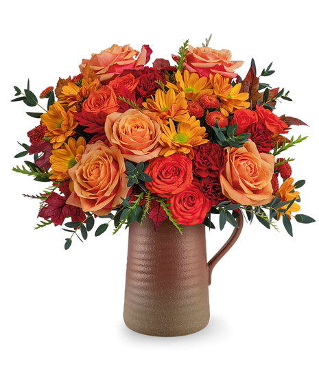 Terra Bloom Bouquet with orange roses, maroon carnations, chrysanthemums, and fall foliage in a rustic Terra Bloom Pitcher.
