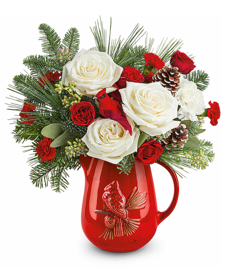 Scarlet Cardinal Bouquet with red spray roses, white carnations, and red miniature carnations accented with seeded eucalyptus and winter greens in a cardinal pitcher.