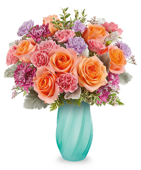 Blue Radiance Bouquet with orange roses, pink and lavender blooms arranged in a sculpted blue glass vase