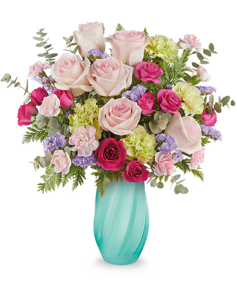 Petal Tide Bouquet with pink roses, green carnations, and lavender accents arranged in a sculpted blue glass vase