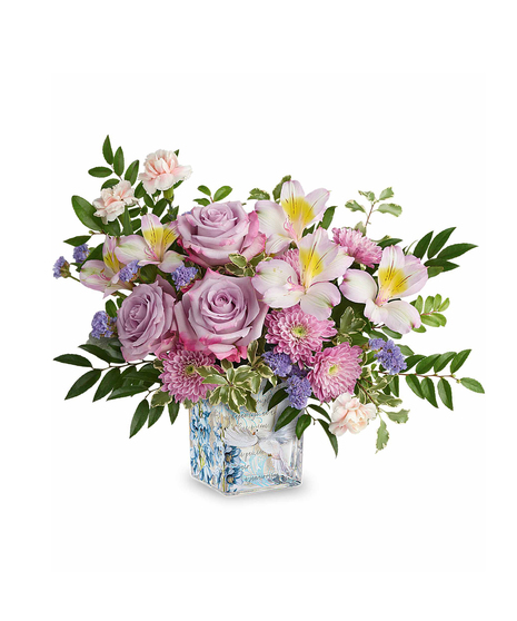 Lavender and pastel spring flower arrangement in decorative glass cube with dove design.