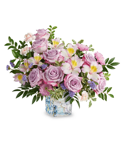 Lavender and pastel spring flower arrangement in decorative glass cube with dove design.