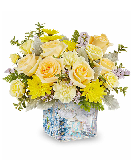 Yellow spring flower arrangement in decorative glass cube with dove and floral design.