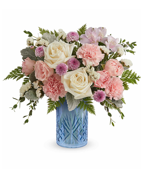 blue belle bouquet with pink, white and lavender flowers in a blue glass vase