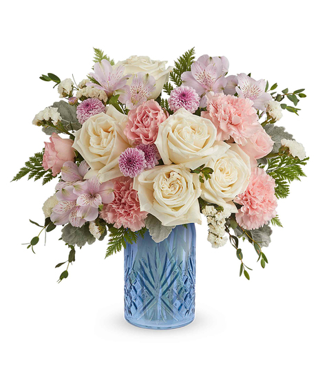 blue belle bouquet with pink, white and lavender flowers in a blue glass vase