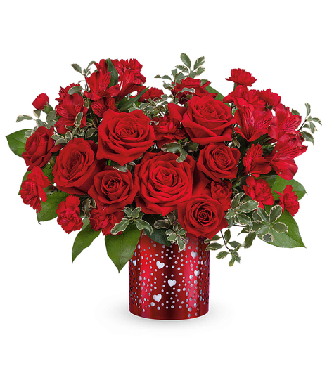 Romantic all-red flower arrangement with roses, alstroemeria, and carnations displayed in a red metal lantern with heart cutouts