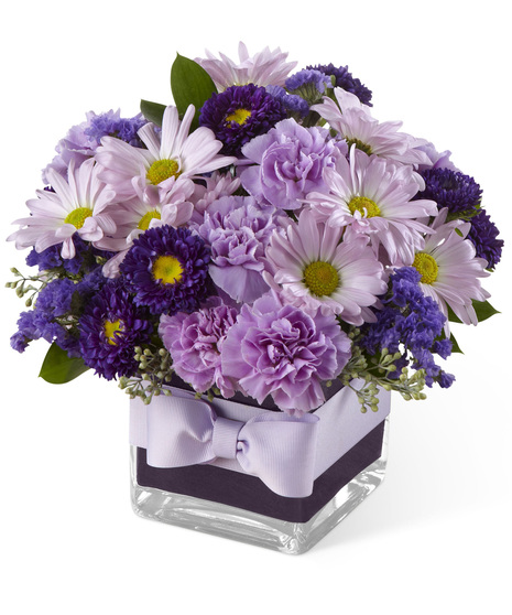 Lavender and purple flowers in a glass cube