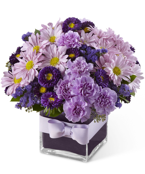 Lavender and purple flowers in a glass cube