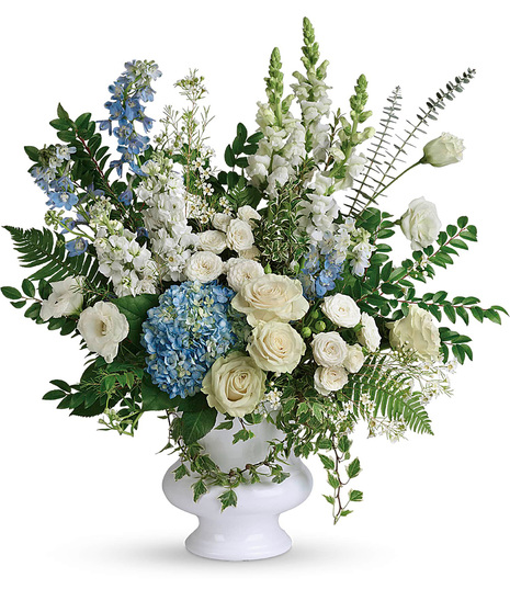 White and blue funeral flowers in a white vase