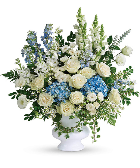 White and blue funeral flowers in a white vase