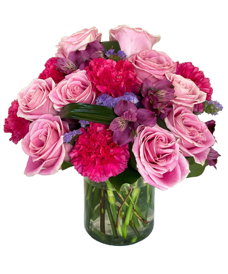 Vibrant and colourful arrangement designed in a clear cylinder vase.