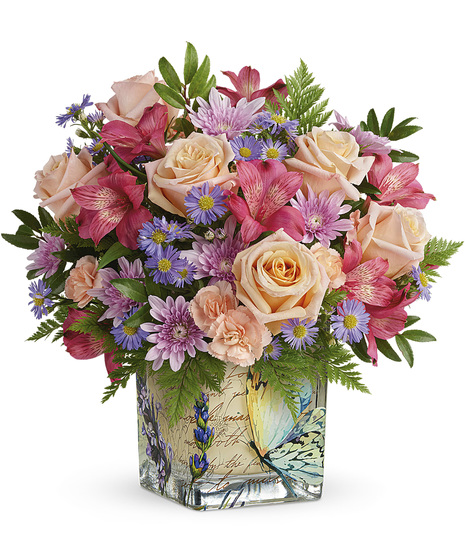Fresh flowers arranged in a vintage butterfly cube
