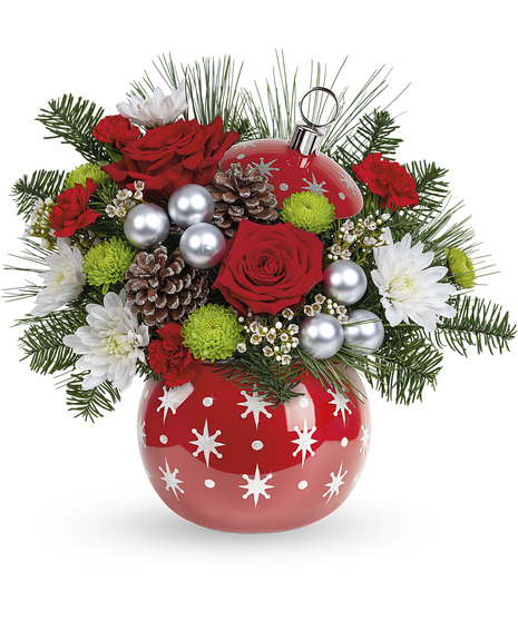 Christmas flowers arranged in a shiny red ornament vase
