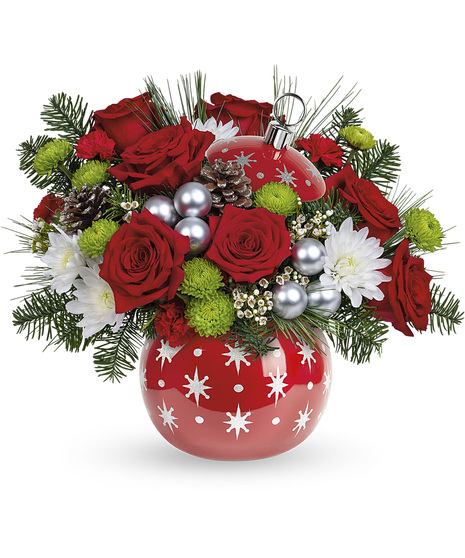 Christmas flowers arranged in a shiny red ornament vase