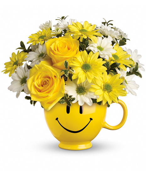Yellow and white flowers in a happy face mug